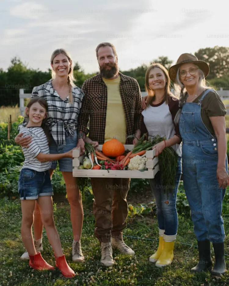 Famiglia in campagna con una cassetta di verdure appena raccolte